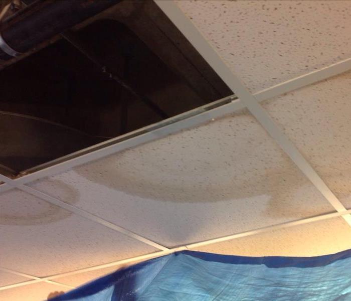 Stained ceiling tiles were removed leaving an opening to where the water is infiltrating from.
